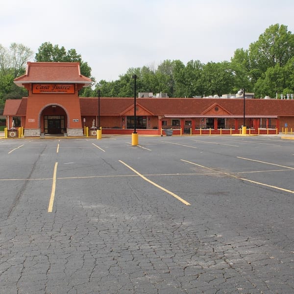 The exterior of Casa Juarez Mexican Town, a red building with a large empty parking lot in front.